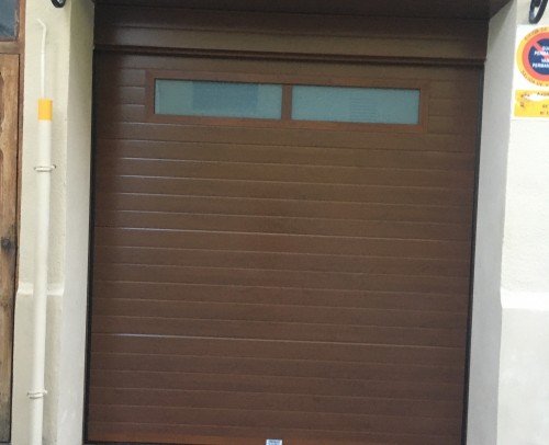 puerta seccional acanalada imitación madera con dintel y dos ventanas fijas, con vidrio laminar 3+3