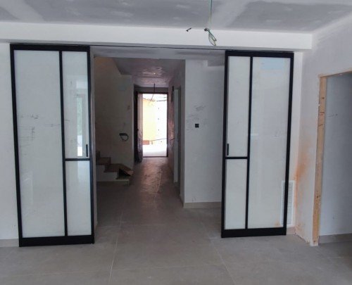 Puertas correderas en aluminio negro con guía oculta