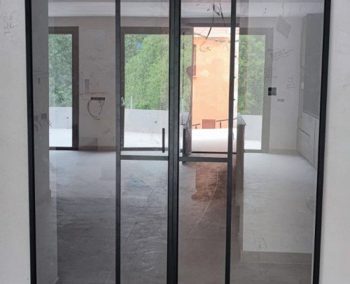 Puertas correderas en aluminio negro con guía oculta