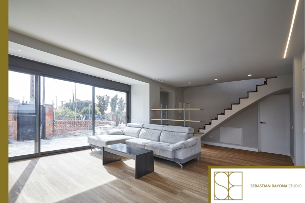 Salón elegante y contemporáneo con interiorismo de lujo, paleta neutra y materiales nobles.