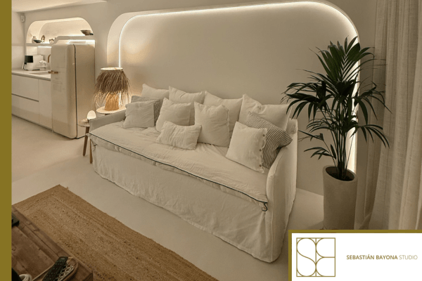 Contemporary elegant and cozy living room with a white sofa, integrated lighting, and natural materials.