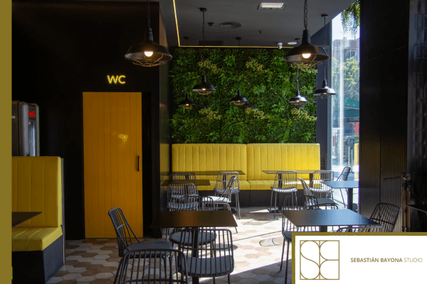 Contemporary restaurant interior with elegant design%2C vertical greenery%2C yellow seating%2C and warm lighting.