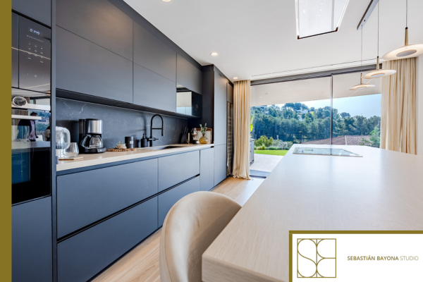 Cocina contemporánea con luz natural isla central y vistas al exterior