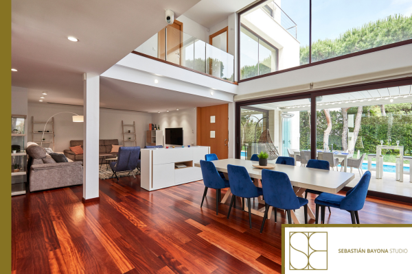 Salón comedor luminoso de lujo con grandes ventanales doble altura y conexión al exterior
