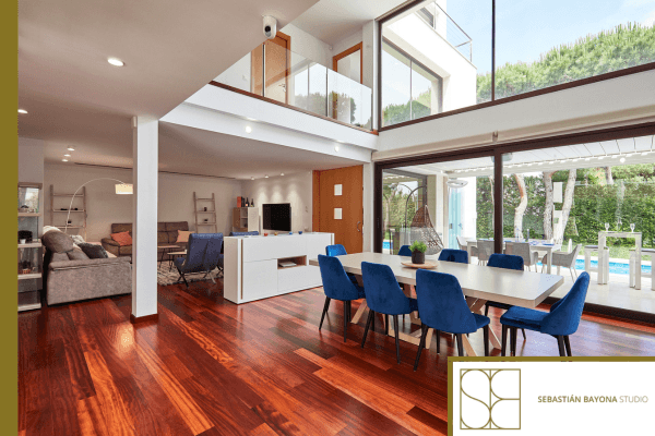 Salón comedor luminoso de lujo con grandes ventanales doble altura y conexión al exterior