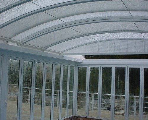 Cerramiento de piscina con techo plegable de aluminio y vidrio transparente