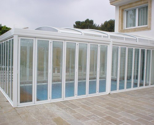 Cerramiento de piscina con techo plegable de aluminio y vidrio transparente